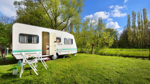 Caravan on green lawn